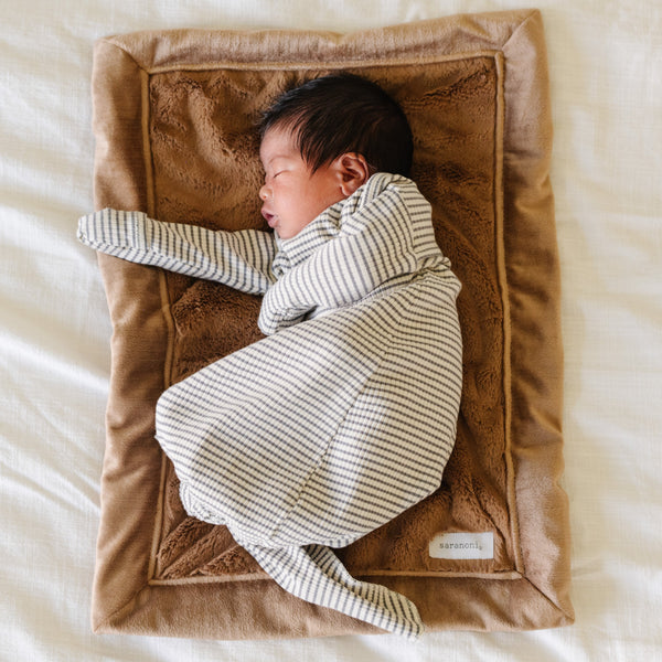 A newborn baby boy lays on a Mini Hazelnut Colored Lush Saranoni Blanket. The soft blanket is a small blanket and a baby blanket or toddler blanket.