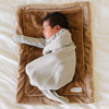 A newborn baby boy lays on a Mini Hazelnut Colored Lush Saranoni Blanket. The soft blanket is a small blanket and a baby blanket or toddler blanket.