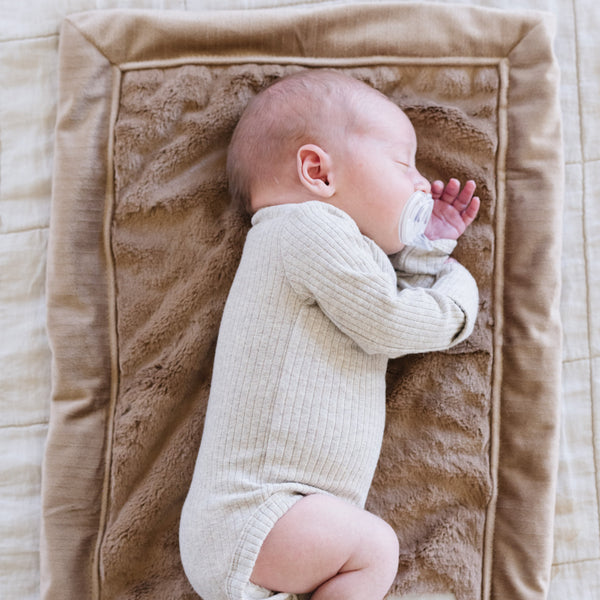 A newborn baby boy lays on a Mini Hazelnut Colored Lush Saranoni Blanket. The soft blanket is a small blanket and a baby blanket or toddler blanket.