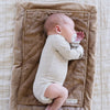 A newborn baby boy lays on a Mini Hazelnut Colored Lush Saranoni Blanket. The soft blanket is a small blanket and a baby blanket or toddler blanket.