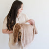 A mother holds her newborn and a Luxury Receiving Hazelnut Colored Lush Saranoni Blanket. The soft blanket is a small blanket and a baby blanket or toddler blanket.