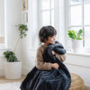 A little boy hugs a Luxury Toddler Charcoal Colored Lush Saranoni Blanket. The soft blanket is a toddler blanket or baby blanket.