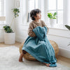 A little boy holds a Luxury Receiving Mineral Blue Colored Lush Saranoni Blanket. The soft blanket is a small blanket and a baby blanket or toddler blanket.