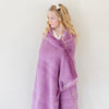 A little girl wrapped in a Luxury Toddler Fairy Wings (light pink purple) Colored Lush Saranoni Blanket. The soft blanket is a toddler blanket or baby blanket.