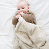 A baby boy holds a Mini Buttermilk (light tan) Colored Lush Saranoni Blanket. The soft blanket is a small blanket and a baby blanket or toddler blanket.