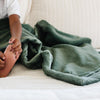 A little boy holds a Toddler Hunter Green Colored Lush Luxury Saranoni Blanket. The soft blanket is small blanket and a baby blanket or toddler blanket.