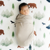 Baby boy swaddled in Saranoni stretch swaddle while laying on Yosemite Cotton Muslin Crib sheet.