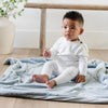 A little boy sits on a Toddler Chambray (cloud-like light blue) Colored Lush Luxury Saranoni Blanket. The soft blanket is a baby blanket or toddler blanket.