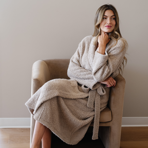 Woman wearing taupe bamboni robe sitting in chair. 