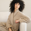 Woman sitting on couch wearing taupe bamboni cozy robe. 