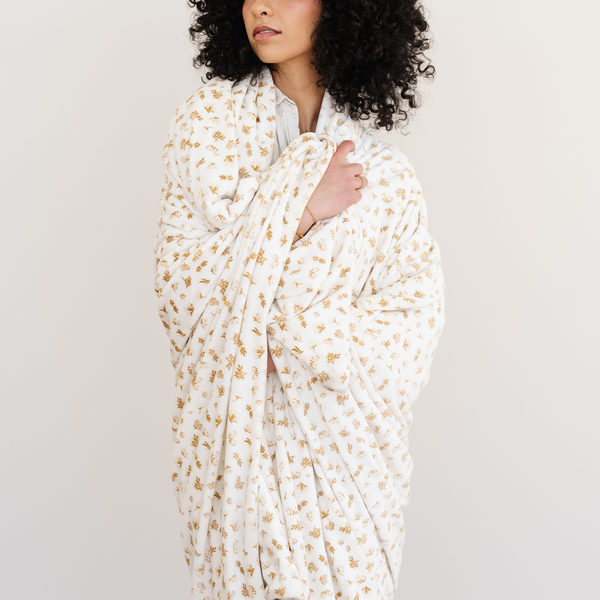 Woman wrapped in Minky Stretch blanket in the florals print. 