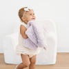 Toddler girl holding a purple dream faux fur mini baby blanket. 