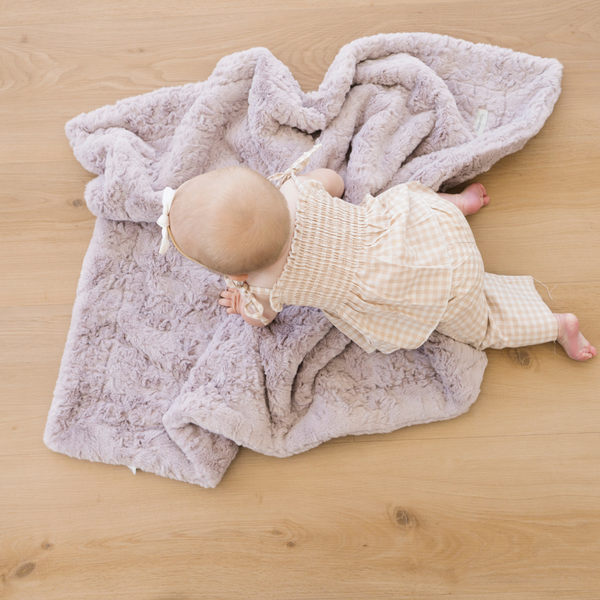 Baby girl crawling on Lilac Dream Faux Fur Receiving Blanket.