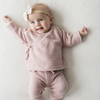 Baby in a pink outfit with a white background