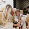 A mother and her toddler son happily playing with a fluffy stuffed animal in a cozy living room. The child, smiling, holds a soft plush bear, showcasing the joy of childhood and comfort. Surrounded by warm blankets and a nurturing atmosphere, this heartwarming scene highlights the perfect gift for kids, ideal for cuddling and imaginative play.