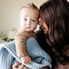 A mother holds her little boy with a buttery-soft Saranoni blanket, featuring a breathable, plush waffle texture in a soothing blue hue. This luxury receiving blanket is the best baby blanket as a  newborn blanket, infant blanket, baby blanket, or toddler blanket—perfect as a cozy blanket for snuggles or a must-have infant blanket. Designed for softness and comfort, this plush baby blanket makes an ideal baby gift or gift for new moms. Enjoy this luxury blanket!