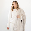 A woman holds a light tan luxurious patterned faux fur extra large throw blanket that is a Saranoni blanket. This ultra-soft, cozy blanket adds a touch of elegance and warmth to any space, perfect as a soft oversized blanket or fluffy blanket for lounging. Ideal for those seeking a high-quality artificial fur blanket or luxury blanket, this versatile and stylish soft blanket enhances both comfort and decor. Shop the best blankets and throws for ultimate relaxation and cozy vibes.