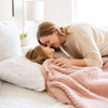 A mother, her daughter, and a luxurious ribbed Bamboni® blanket by Saranoni, the blanket is light pink. This ultra-soft blanket is crafted from bamboo rayon and poly microfiber, making it lightweight, breathable, and fluffy. Ideal as a cozy blanket, throw blanket, luxury blanket, soft blanket, or stylish home accent, this Saranoni blanket brings warmth, comfort, and timeless elegance to any living room or bedroom.