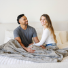 A husband and wife with a cashmere colored luxurious patterned faux fur throw blanket that is a Saranoni blanket. This ultra-soft, plush throw blanket adds a touch of elegance and warmth to any space, perfect as a soft throw blanket or fluffy blanket for lounging. Ideal for those seeking a high-quality artificial fur blanket or luxury blanket, this versatile and stylish soft blanket enhances both comfort and decor. Shop the best blankets and throws for ultimate relaxation and cozy vibes.