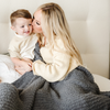 A mother, her little boy, and a luxurious ribbed Bamboni® blanket by Saranoni, the blanket is a charcoal blanket. This ultra-soft blanket is crafted from bamboo rayon and poly microfiber, making it lightweight, breathable, and fluffy. Ideal as a cozy blanket, throw blanket, luxury blanket, soft blanket, or stylish home accent, this Saranoni blanket brings warmth, comfort, and timeless elegance to any living room or bedroom.