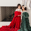 Two young girls by the fireplace with holiday stockings, each wrapped in cozy double ruched blankets—one in festive red and the other in plush green. Perfect for capturing the warmth and joy of the holiday season with luxurious, seasonal decor. The soft blankets are luxury blankets and Saranoni blankets.