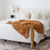 A copper colored luxurious patterned faux fur throw blanket that is a Saranoni blanket is on a bed. This ultra-soft, plush throw blanket adds a touch of elegance and warmth to any space, perfect as a soft throw blanket or fluffy blanket for lounging. Ideal for those seeking a high-quality artificial fur blanket or luxury blanket, this versatile and stylish soft blanket enhances both comfort and decor. Shop the best blankets and throws for ultimate relaxation and cozy vibes.