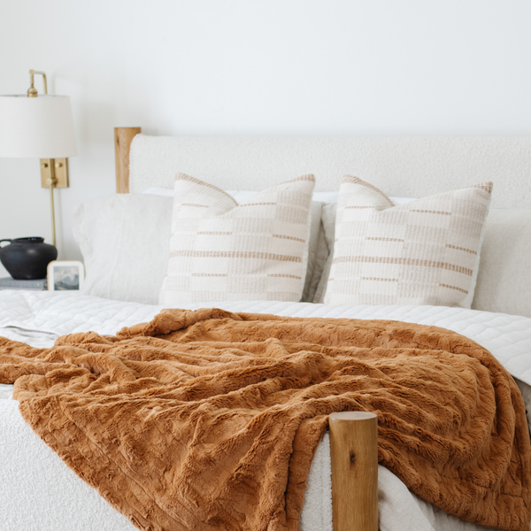 A copper colored luxurious patterned faux fur extra large throw blanket that is a Saranoni blanket is on a bed. This ultra-soft, cozy blanket adds a touch of elegance and warmth to any space, perfect as a soft oversized blanket or fluffy blanket for lounging. Ideal for those seeking a high-quality artificial fur blanket or luxury blanket, this versatile and stylish soft blanket enhances both comfort and decor. Shop the best blankets and throws for ultimate relaxation and cozy vibes.