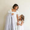 A mother stands by her daughter and holds a dove colored extra large patterned faux fur throw Saranoni Luxury Blanket. The soft blanket is an oversized throw blanket.