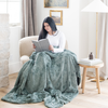 A woman reads and has a dusty green luxurious patterned faux fur throw blanket that is a Saranoni blanket. This ultra-soft, plush throw blanket adds a touch of elegance and warmth to any space, perfect as a soft throw blanket or fluffy blanket for lounging. Ideal for those seeking a high-quality artificial fur blanket or luxury blanket, this versatile and stylish soft blanket enhances both comfort and decor. Shop the best blankets and throws for ultimate relaxation and cozy vibes.