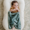 A newborn sleeps under a Eucalyptus colored Lush Saranoni Blanket. The soft blanket is a small blanket and a baby blanket.