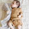 A Little Baby boy hugging a Mini Saranoni Lush baby Blanket that is Feather Colored (similar to a light tan).