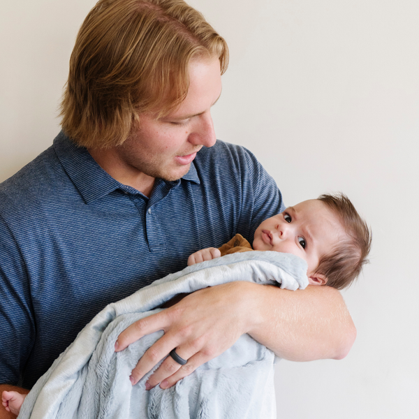 A father holds his little boy in a Luxury Mini Storm Cloud (light dusty blue) Colored Lush Saranoni Blanket. The soft blanket is a small blanket and a baby blanket or toddler blanket.