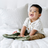 A baby boy holds a Mini Fern Colored Lush Saranoni Blanket. The soft blanket is a small blanket and a baby blanket.