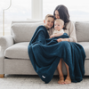 A mother and her two little boys and a Bamboni® blanket by Saranoni. This ultra-soft blanket is a blue blanket and made from a premium blend of bamboo rayon and poly microfiber, offering a lightweight, breathable, and fluffy feel. Perfect as a extra large blanket, luxury blanket, or soft blanket, it adds warmth and elegance to any living room, bedroom, or home décor setting. Designed for ultimate comfort, this buttery-soft Saranoni blanket is ideal for gifting. Enjoy this cozy blanket for years to come! 