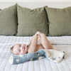 A smiling baby boy with a double-layer Bamboni® baby blanket. The plush, breathable blanket features a two-tone blue and cream star design, offering ultimate softness and warmth. Made from Saranoni’s signature stretchy, cloud-like Bamboni® fabric, this luxury baby blanket provides comfort for naps, tummy time, and on-the-go snuggles. The perfect blend of warmth and breathability, it’s a must-have for parents seeking high-quality, ultra-soft blankets. The soft blanket is a mini blanket and Saranoni blanket. 