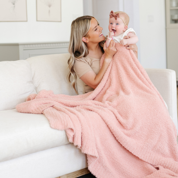 A mother, her little girl, and a Bamboni® blanket by Saranoni. This ultra-soft blanket is a peach blanket and made from a premium blend of bamboo rayon and poly microfiber, offering a lightweight, breathable, and fluffy feel. Perfect as a extra large blanket, luxury blanket, or soft blanket, it adds warmth and elegance to any living room, bedroom, or home décor setting. Designed for ultimate comfort, this buttery-soft Saranoni blanket is ideal for gifting. Enjoy this cozy blanket for years to come!