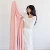 A woman holds a Bamboni® blanket by Saranoni. This ultra-soft blanket is a peach blanket and made from a premium blend of bamboo rayon and poly microfiber, offering a lightweight, breathable, and fluffy feel. Perfect as a extra large blanket, luxury blanket, or soft blanket, it adds warmth and elegance to any living room, bedroom, or home décor setting. Designed for ultimate comfort, this buttery-soft Saranoni blanket is ideal for gifting. Enjoy this cozy blanket for years to come!