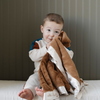 A little boy holds a satin back blanket. The lush blanket is brown with a cream satin border that has little trees on it. The satin back blanket is a lush blanket with a satin border and back. The soft blanket is a luxury blanket and a Saranoni blanket. This receiving blanket is an adorable baby blanket or toddler blanket and perfect for littles. 