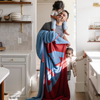 A man with his little boy and little girl holds a blanket with a Superman™ icon on it. The soft blanket is light blue and red. This throw blanket is a luxury blanket and a Saranoni blanket. The blanket is also a double-layer Bamboni® blanket. 