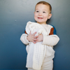 A little boy smiles and holds a buttery-soft Saranoni blanket, featuring a breathable, plush waffle texture in a soothing white hue. This luxury mini blanket is the best baby blanket as a newborn blanket and infant blanket—perfect as a cozy blanket for snuggles or a must-have infant blanket. Designed for softness and comfort, this plush baby blanket makes an ideal baby boy gift or gift for new moms. Enjoy this luxury blanket! 