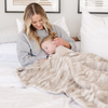 A mother and her daughter and a Saranoni blanket, specifically the tan marbled faux fur/minky extra large blanket, highlighting its ultra-soft texture and luxurious design. This plush blanket features a dual-texture blend of silky minky and cozy faux fur, creating the ultimate cozy blanket for home decor. Perfect luxury blanket for lounging or adding style to any space. Soft blanket, cozy blanket—experience unmatched warmth with a Saranoni blanket. 