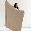 A woman holds up a Bamboni® blanket by Saranoni. This ultra-soft blanket is a taupe blanket and made from a premium blend of bamboo rayon and poly microfiber, offering a lightweight, breathable, and fluffy feel. Perfect as a throw blanket, luxury blanket, plush throw, or soft blanket, it adds warmth and elegance to any living room, bedroom, or home décor setting. Designed for ultimate comfort, this buttery-soft Saranoni blanket is ideal for gifting. Enjoy this cozy blanket for years to come!