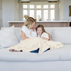 A mother and daughter sit with a Toddler Chiffon (light yellow) Colored Lush Luxury Saranoni Blanket. The soft blanket is a baby blanket or toddler blanket.