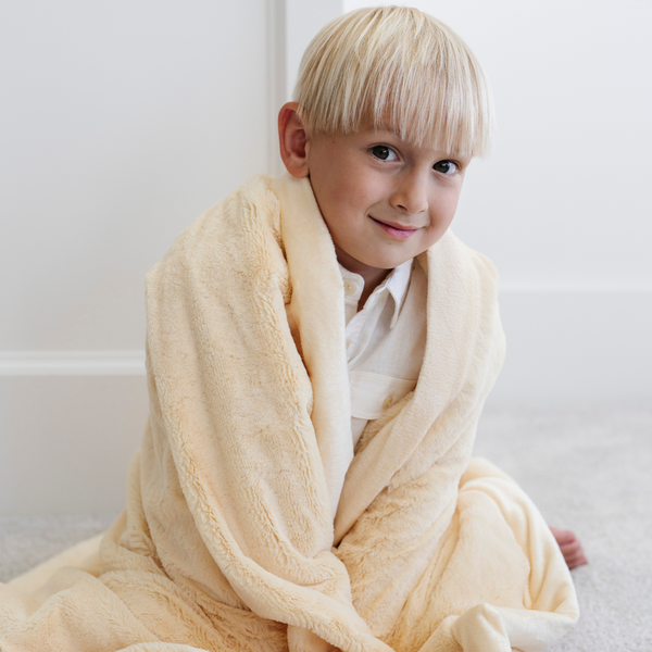 A little boy wrapped in a Toddler Chiffon (light yellow) Colored Lush Luxury Saranoni Blanket. The soft blanket is a baby blanket or toddler blanket.