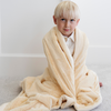 A little boy wrapped in a Toddler Chiffon (light yellow) Colored Lush Luxury Saranoni Blanket. The soft blanket is a baby blanket or toddler blanket.