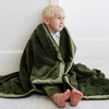 A little boy wrapped in a Toddler Fern Colored Lush Luxury Saranoni Blanket. The soft blanket is a baby blanket or toddler blanket.