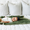 A little boy lays on a Toddler Fern Colored Lush Luxury Saranoni Blanket. The soft blanket is a baby blanket or toddler blanket.