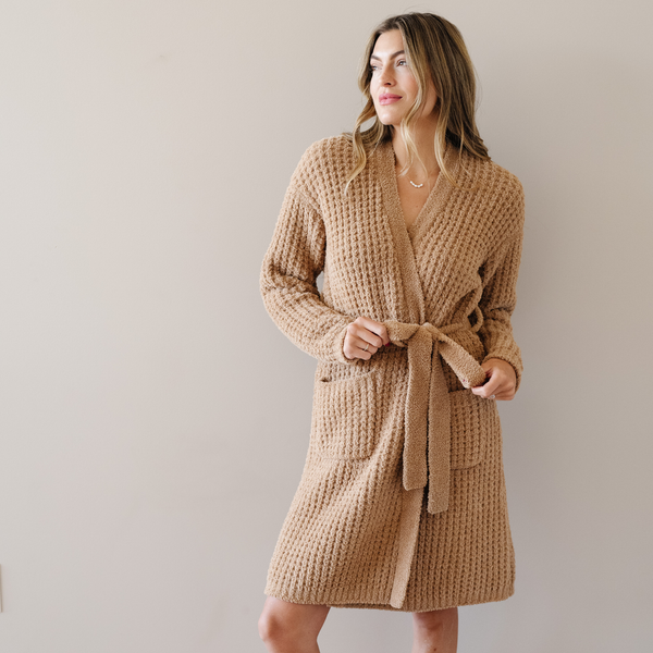 Woman stands wearing the Allspice Saranoni Waffle Knit robe. 