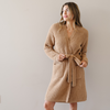 Woman stands wearing the Allspice Saranoni Waffle Knit robe. 