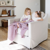 Two little girls sit under a Bamboni® blanket by Saranoni. This ultra-soft blanket is a light purple blanket and made from a premium blend of bamboo rayon and poly microfiber, offering a lightweight, breathable, and fluffy feel. Perfect as a toddler blanket, luxury blanket, or soft blanket, it adds warmth and elegance to any bedroom and is a kids blanket. Designed for ultimate comfort, this buttery-soft Saranoni blanket is ideal for gifting. Enjoy this cozy blanket for years to come!